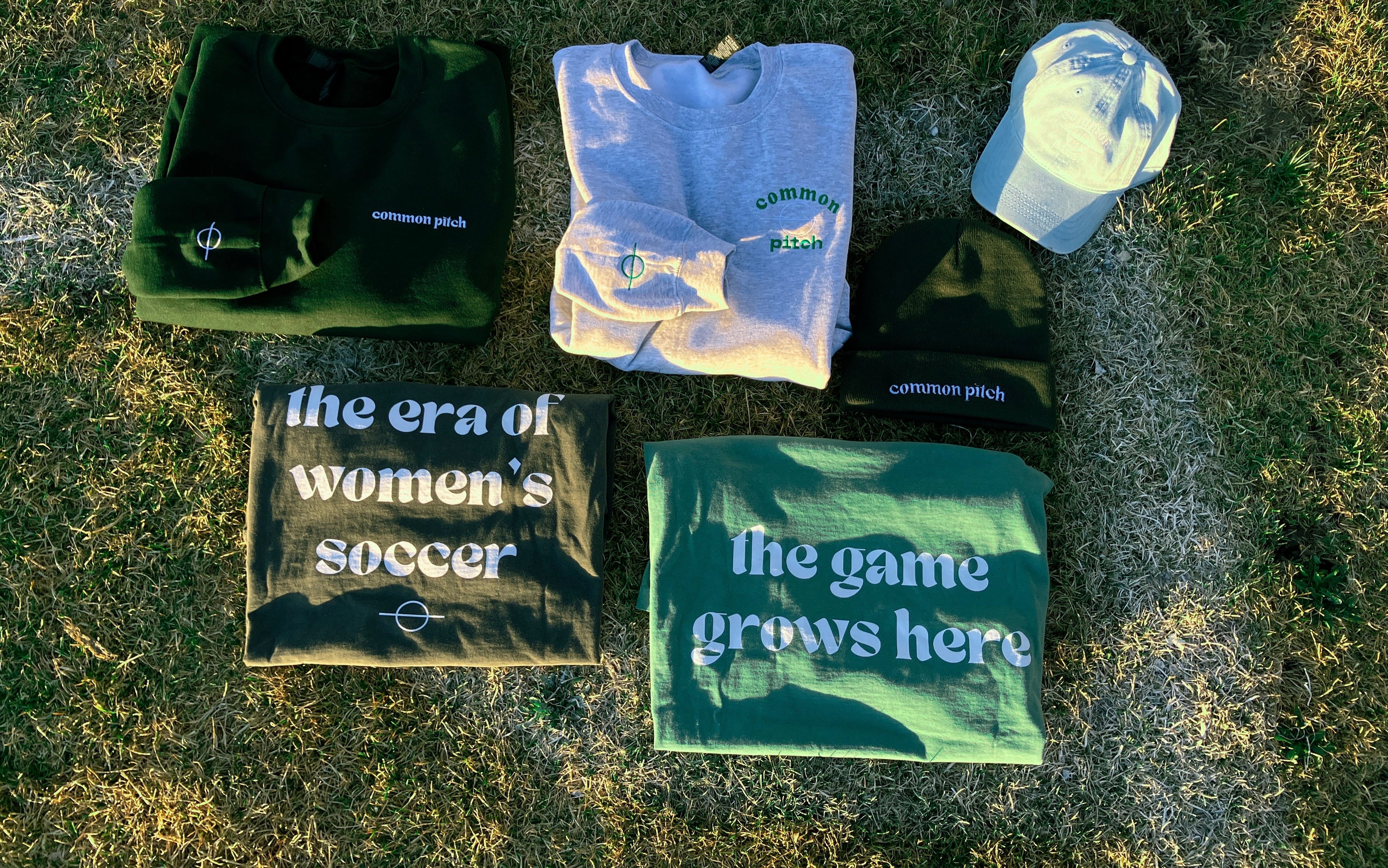 Collection of sports merchandise including t-shirts and a cap on grass